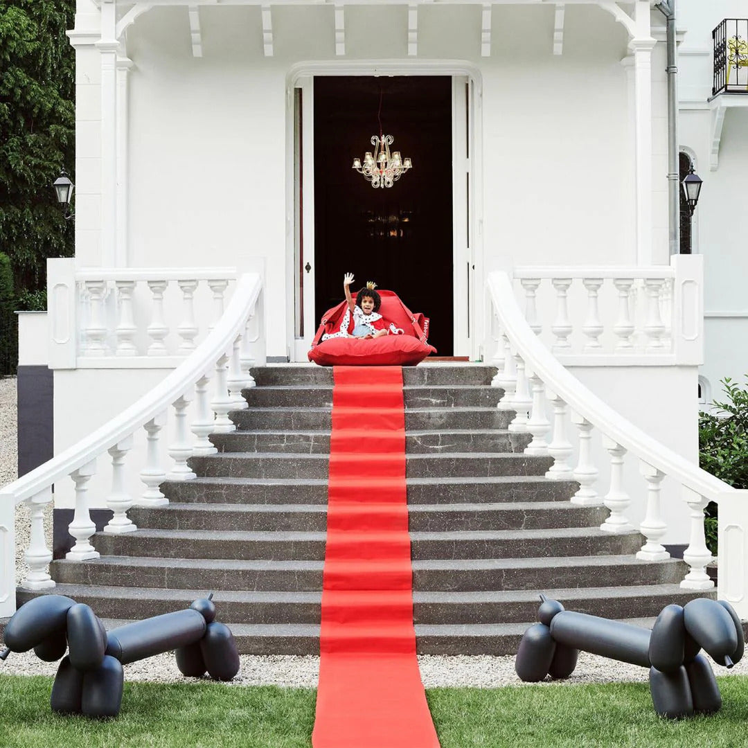 Fatboy Attackle Bench styled as a playful outdoor bench with a red carpet setup.
