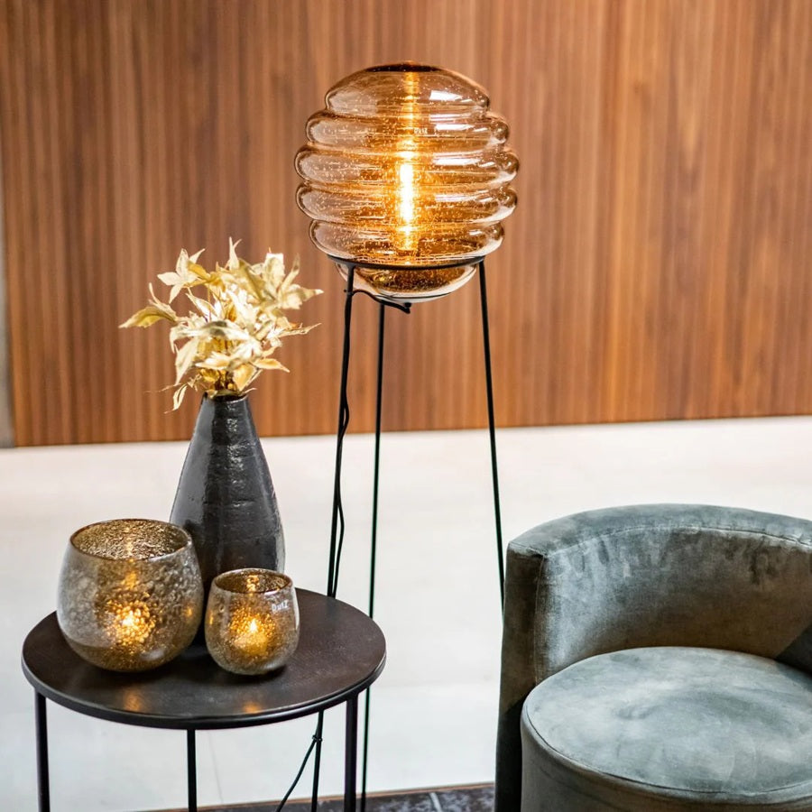 DutZ Hurricane Diva candle holder in amber, styled on a black side table with a floor lamp and velvet accent chair.
