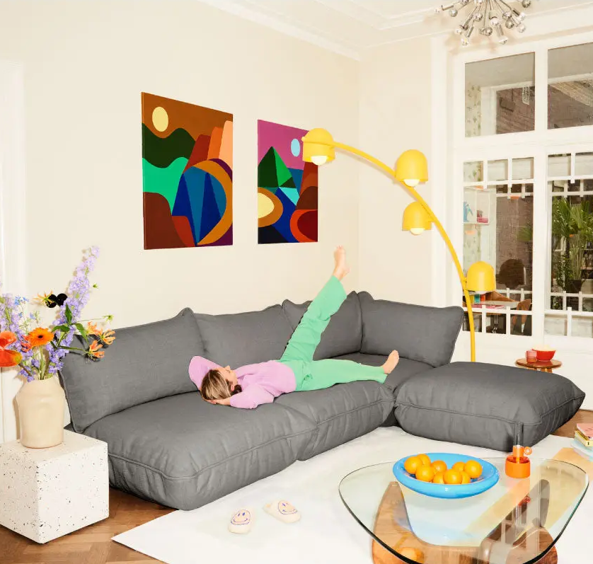 Indoor living room, furnished with Fatboy Sumo weave corner sofa set, Big Lebow Floor Lamp, and Bubble Carpet.