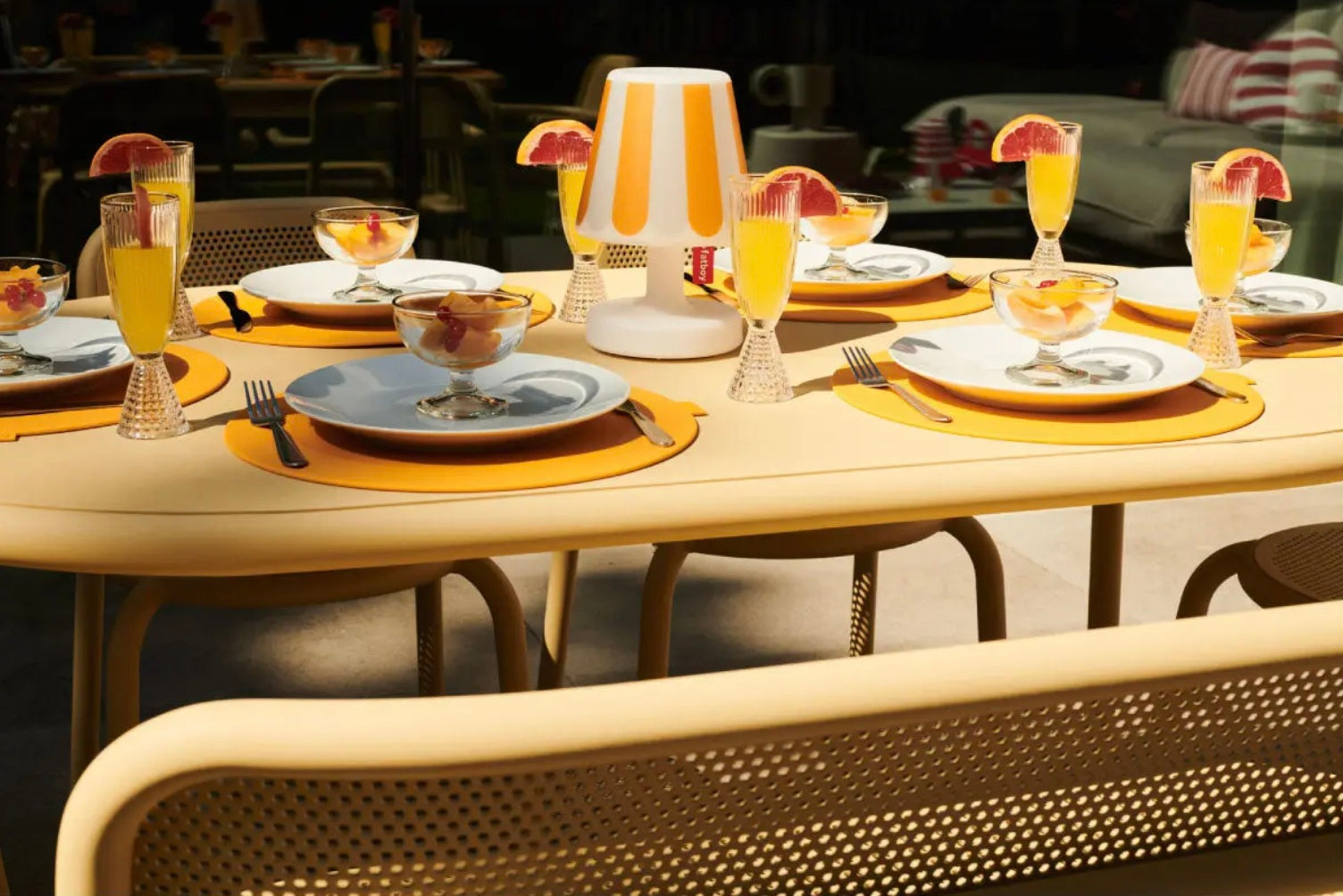 Toni Tavolo dining set paired with the Fatboy Edison table lamp, accented with orange citrus drinks and Place We Met placemats.