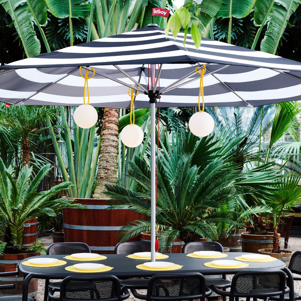 Patio featuring Fatboy Bolleke Hanging Lights outdoor lighting, Fatboy Stripesol Parasol, and Toni Tavolo collection.
