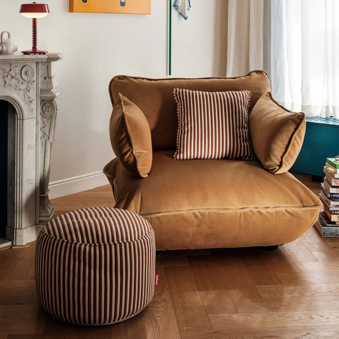Indoor living room, featuring the Fatboy Point Terry Pouf as a footrest for the Sumo Velvet lounge chair.