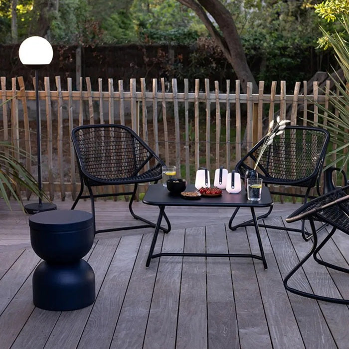 Fermob Piapolo stool in a sleek black finish, displayed on a wooden deck setting, available from Desert River Shop.