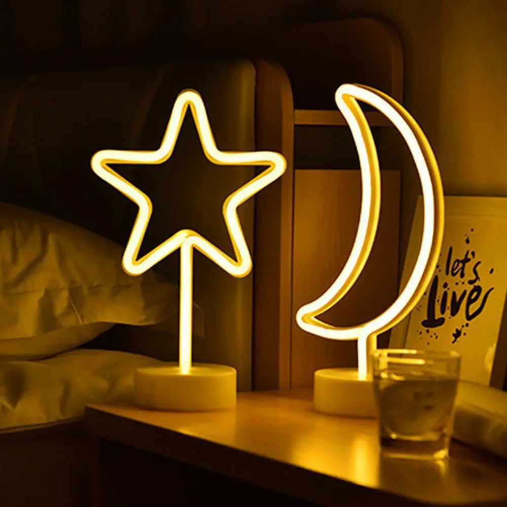 Glowing neon star and crescent moon decorative lamps on a bedside table, casting a cosy golden light in a bedroom with soft bedding.