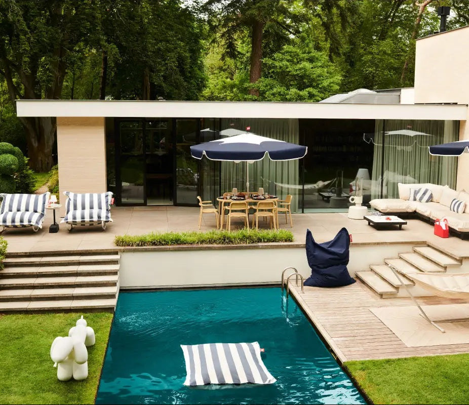 Pool deck featuring Fatboy bean bags, Sunshady parasol, and other outdoor lounge furniture included in the Summer Sale.