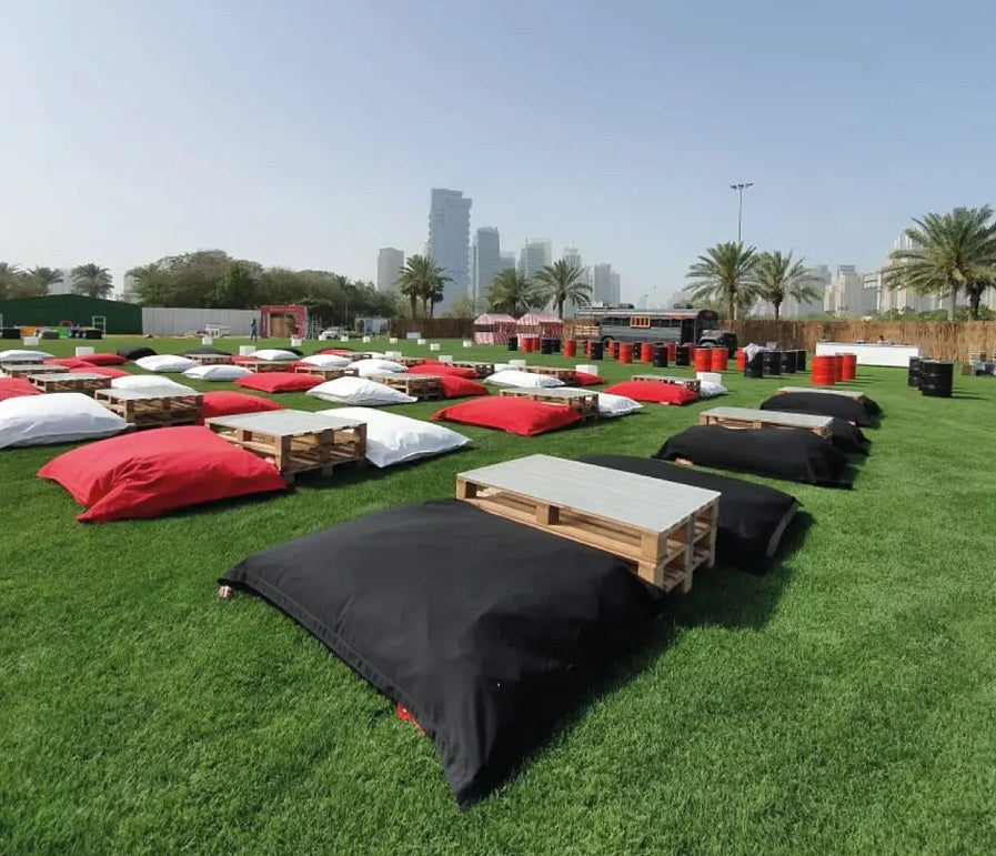 Red, black, and white Fatboy bean bags styled on an outdoor event space in Dubai.